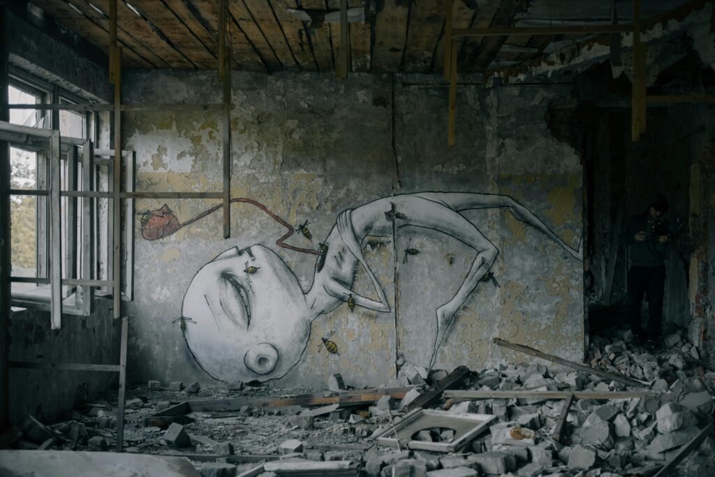 A decaying room featuring surreal graffiti art amidst rubble, capturing urban desolation and decay.